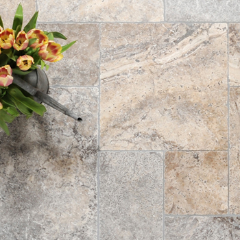 A close-up of light grey travertine floor tiles